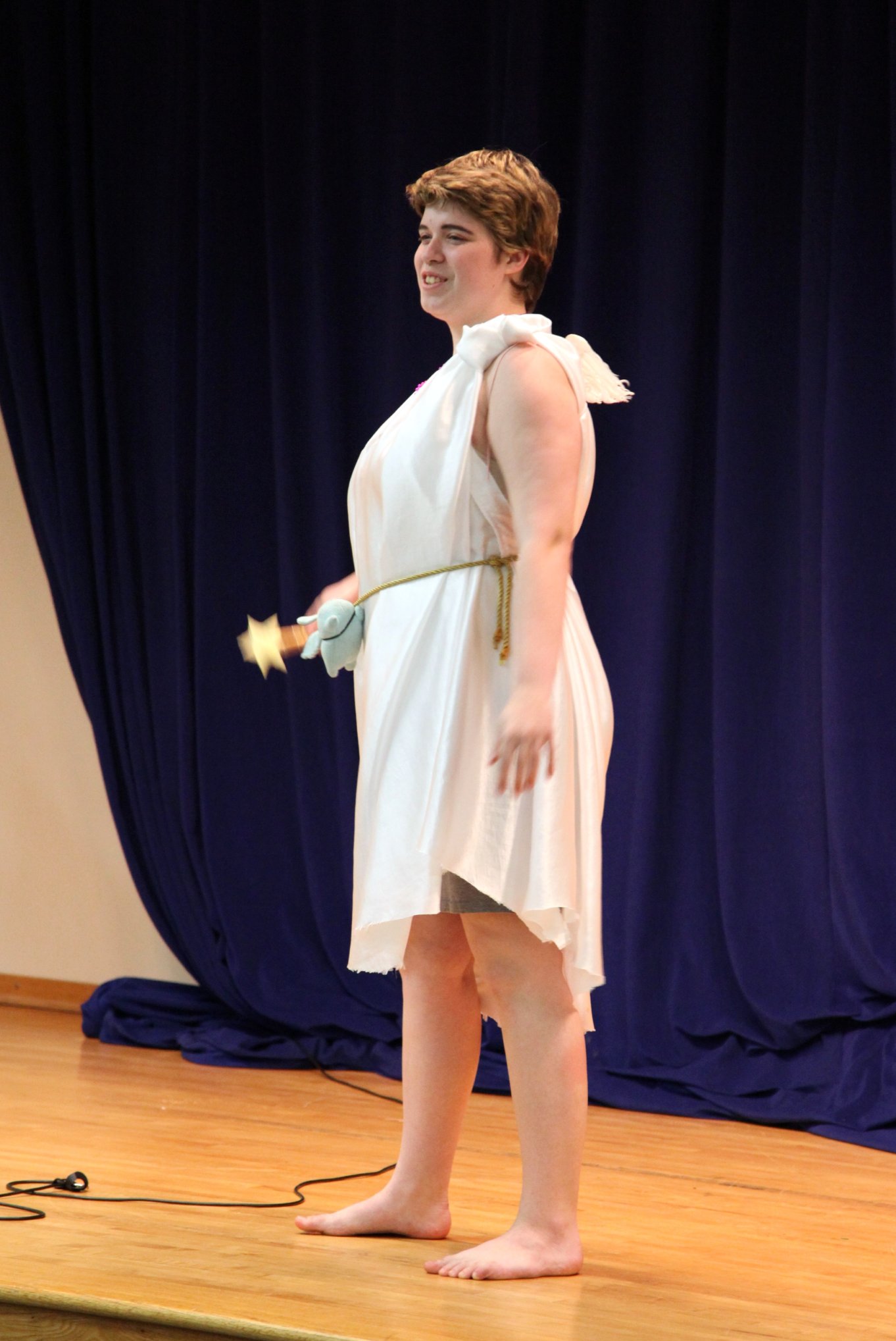 a woman in a dress standing on a stage with a device