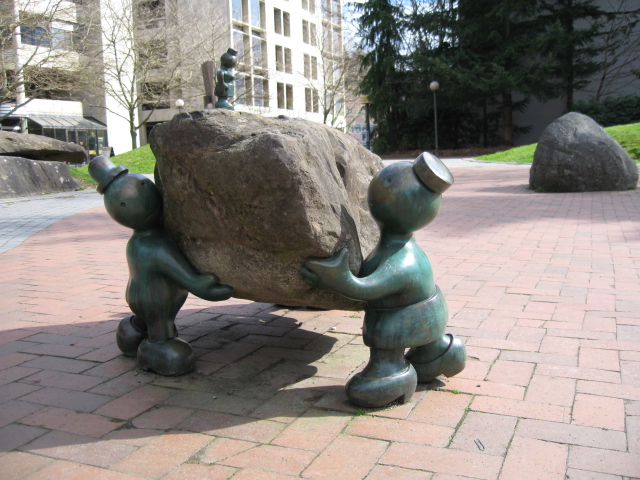 there is a stone on the ground with a sculpture holding onto it