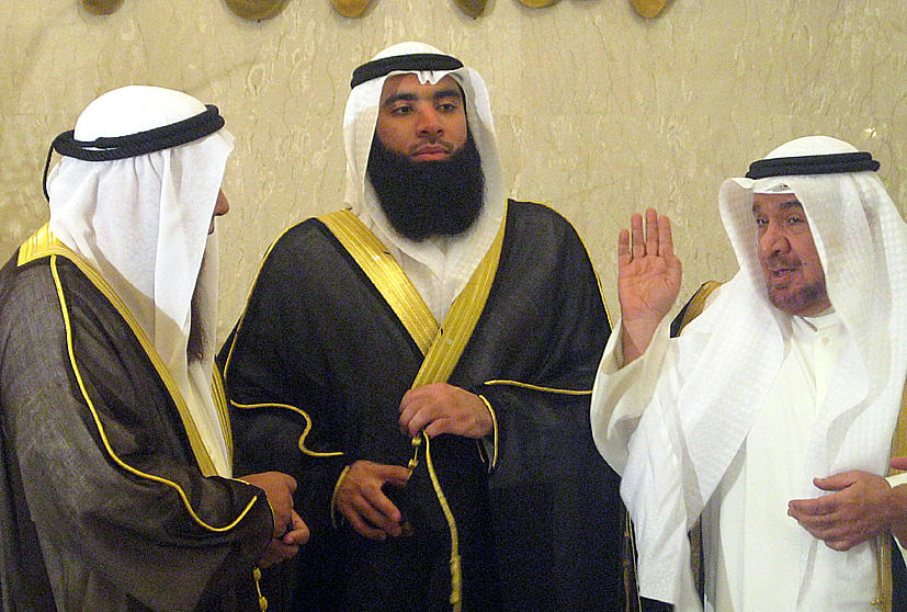 three men standing near each other talking and gesturing