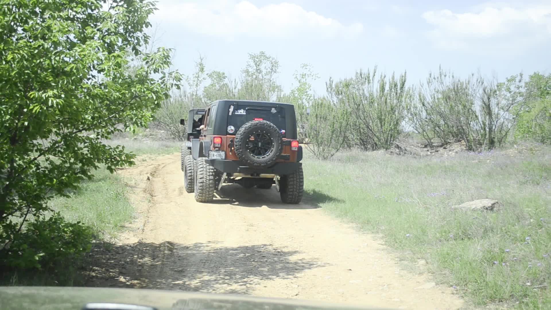 jeep in the middle of the road with large tires on it's tires