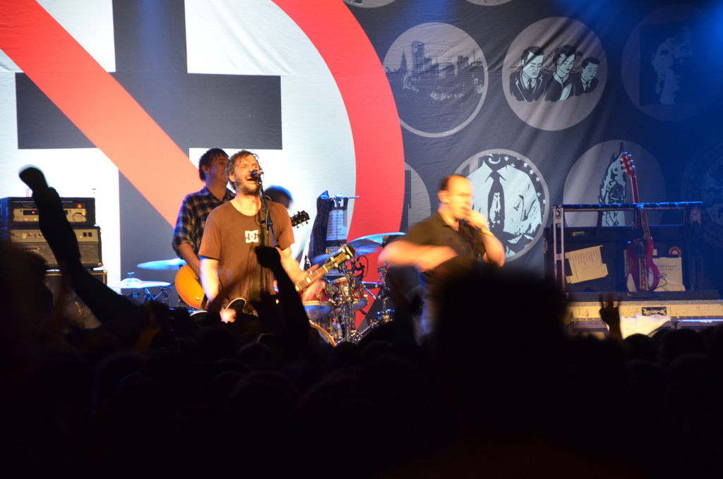 the three men are in front of an audience