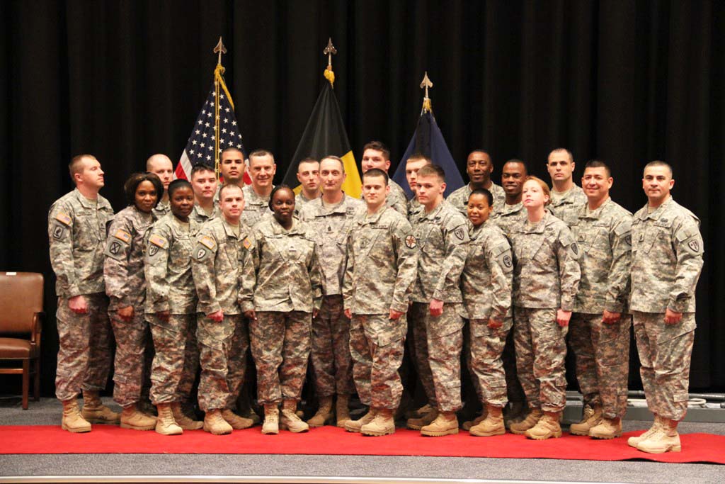 group of soldiers posed on a stage with flags in the background