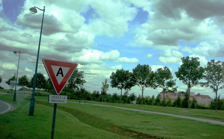 a yield sign sits on the side of a road