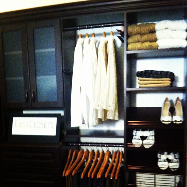 a closet with shoes, dresses and shirts