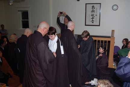 people in robes stand around in a room with signs