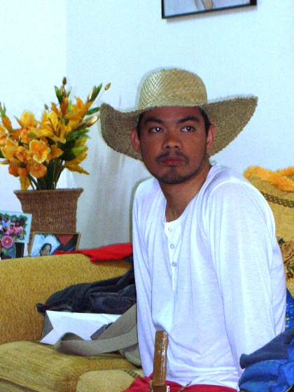a man with a straw hat on sitting on a couch