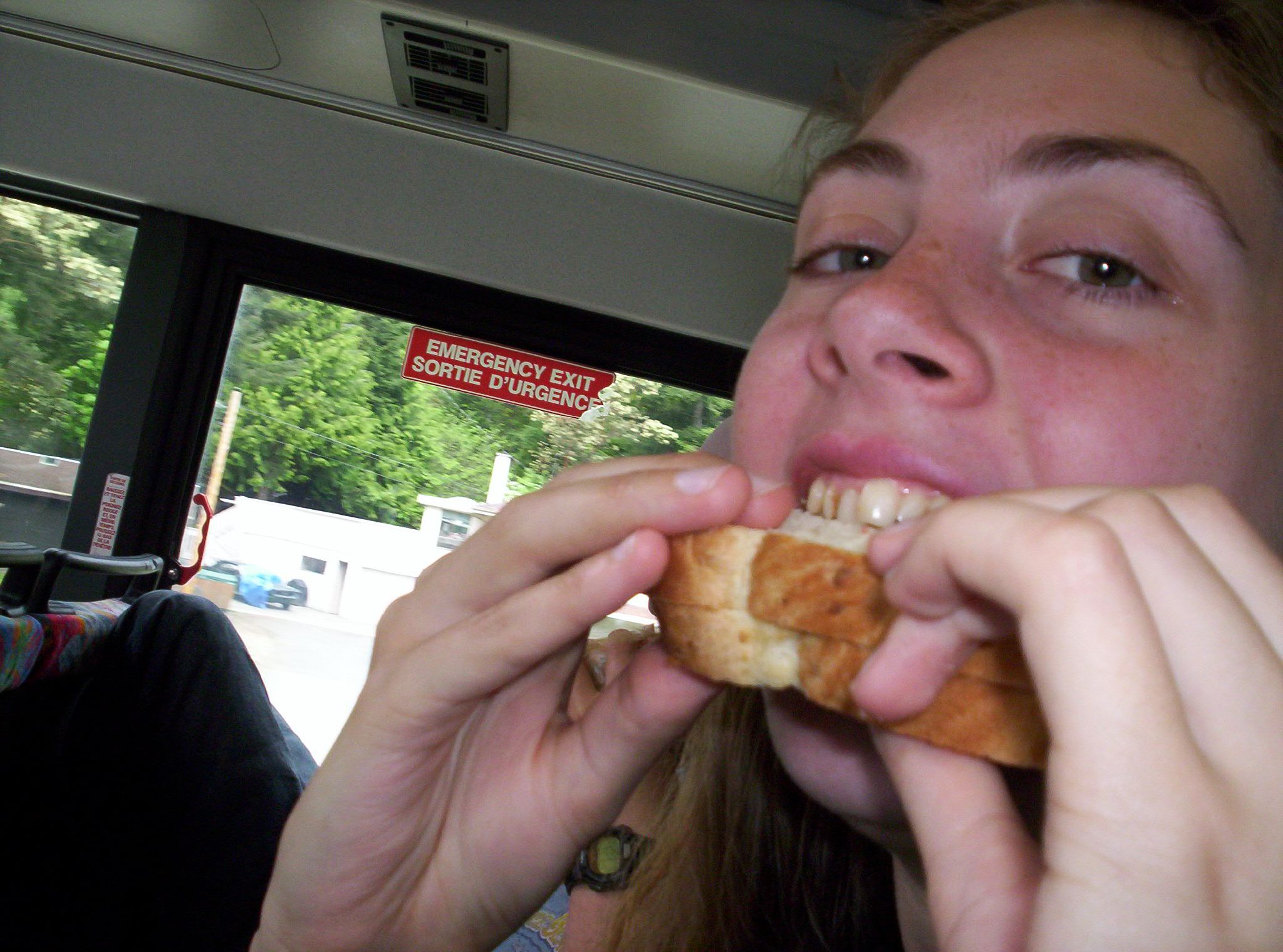 a woman is eating food on a bus