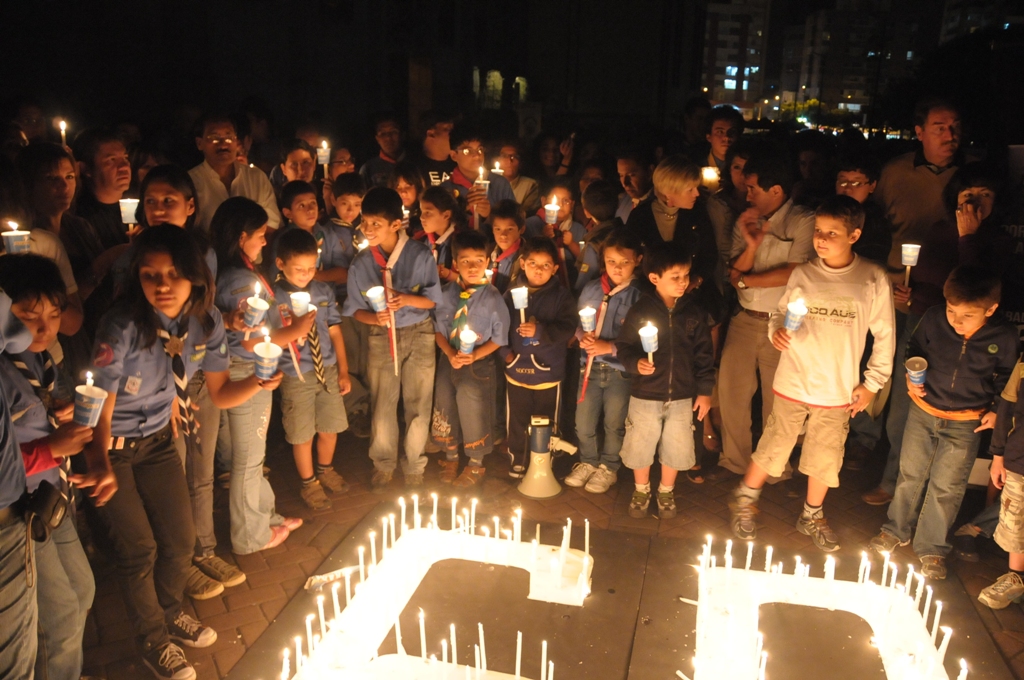 a group of children gathered around birthday candles