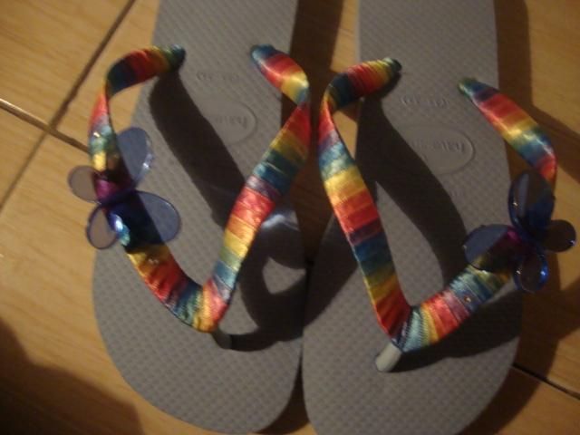 a pair of sandals with ribbons in them on a floor