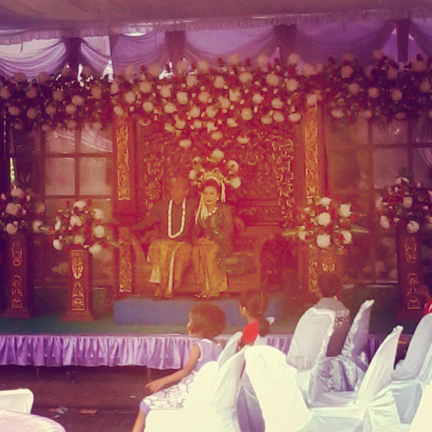 a stage set up for a wedding with two men sitting on the stage