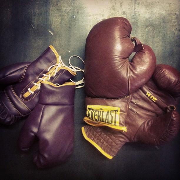 three boxing gloves sitting on a black table