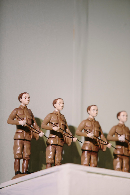 three figurines of soldiers holding guns on a surface