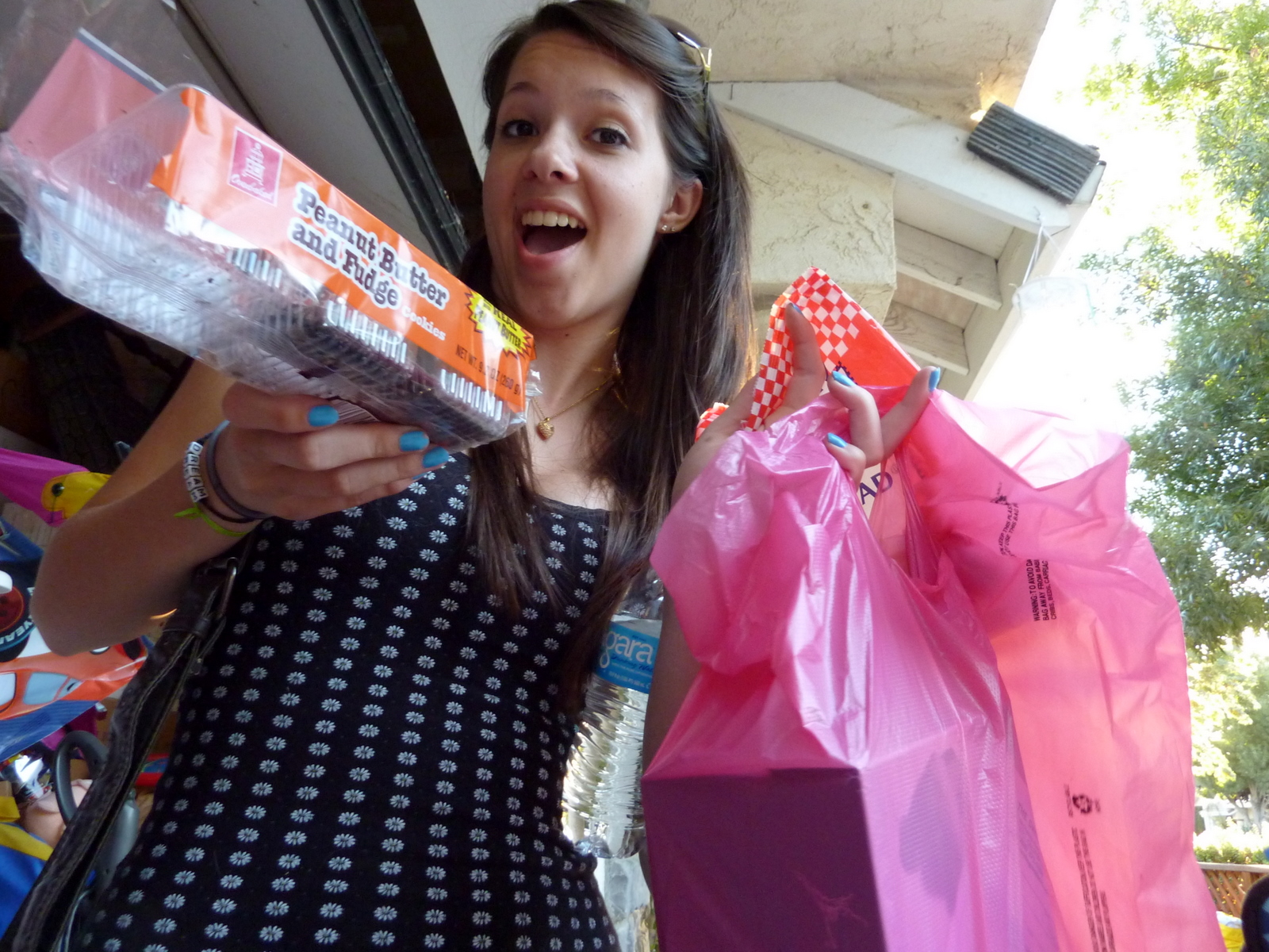a girl standing holding several packages of soing