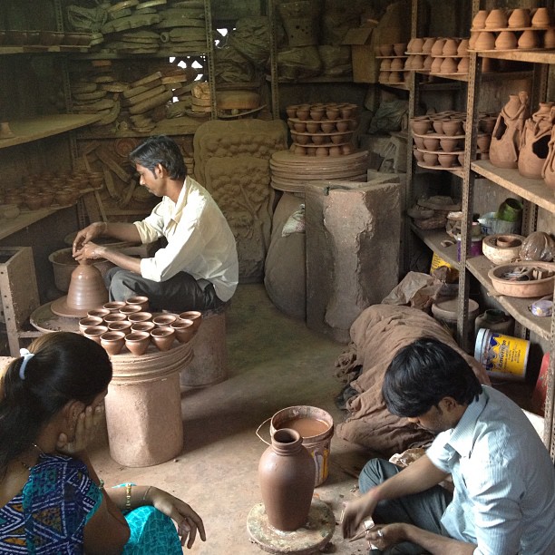 several people are sitting around in a clay shop