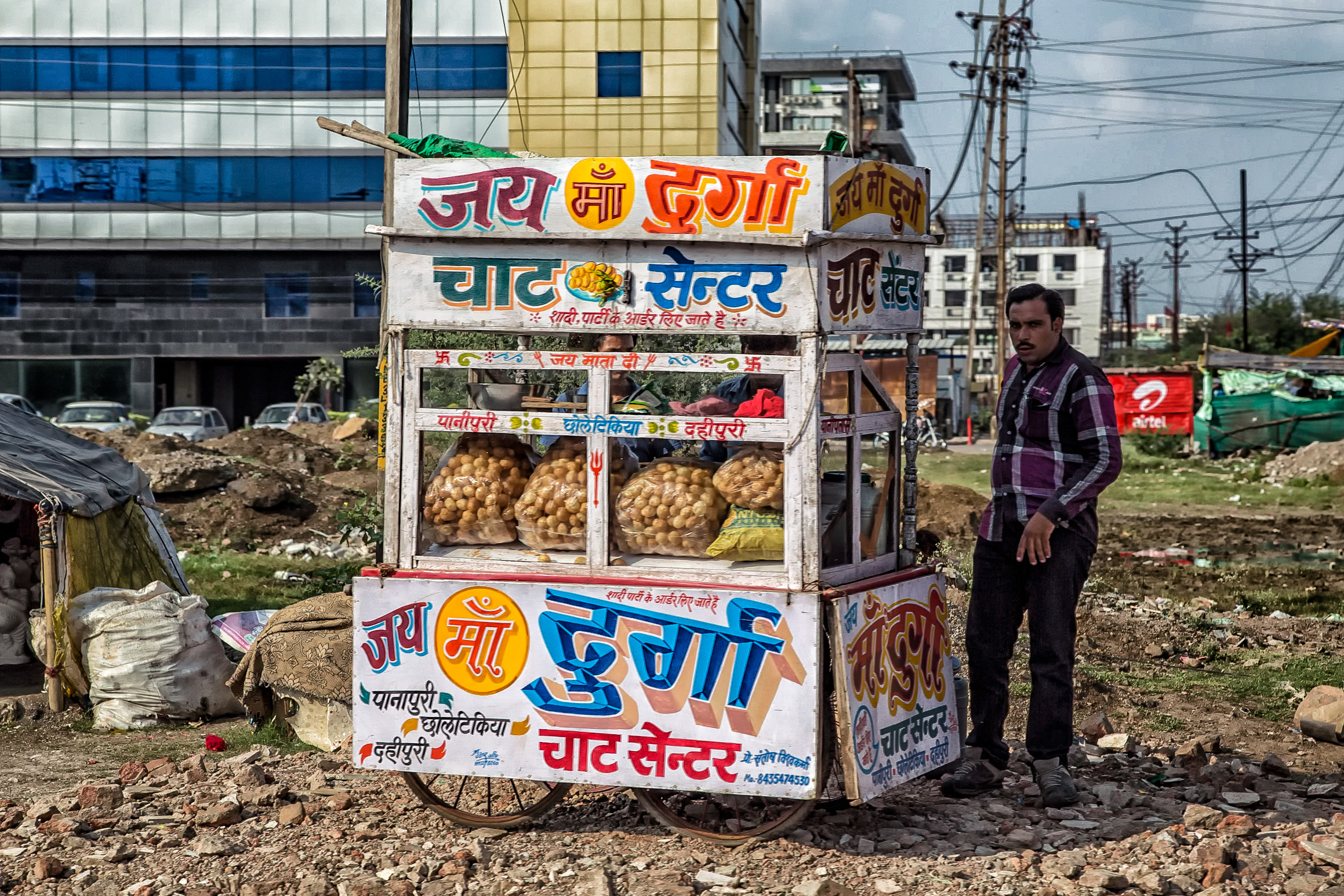 a man standing outside of a small fruit stand