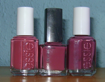 three nail polish bottles on a table, with the top bottle slightly closed