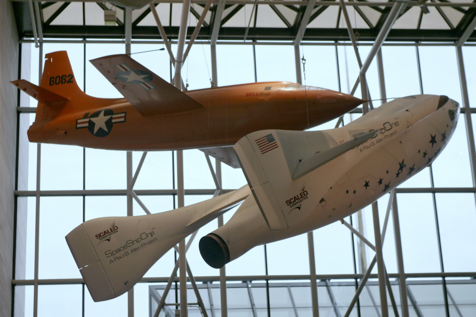 two remote controlled models of airplanes suspended from the ceiling