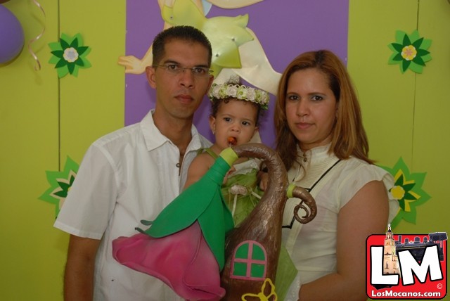 man, woman and child posing with an umbrella in front of a party backdrop