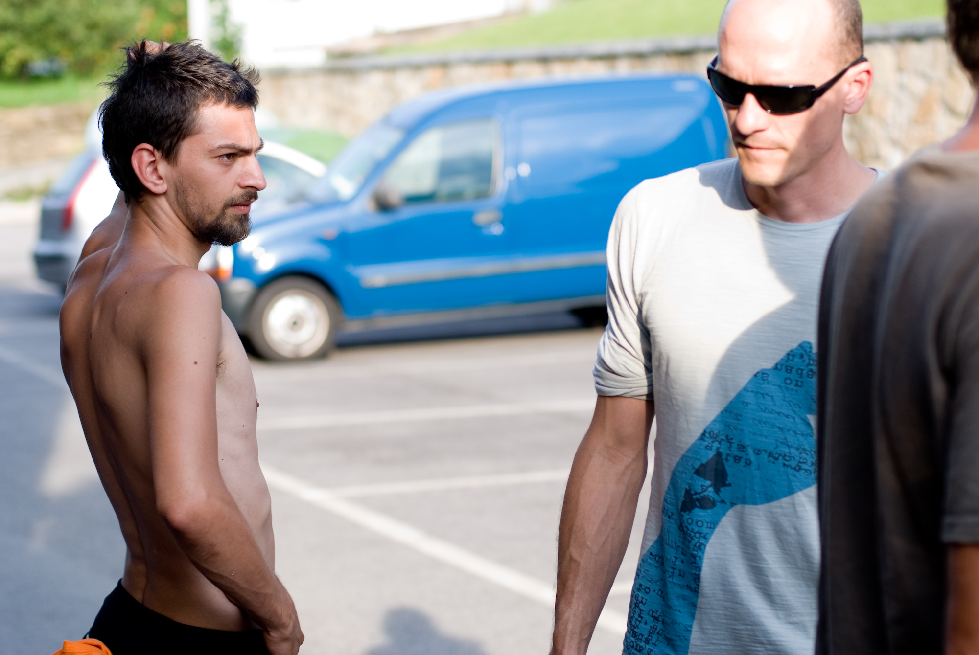 two men are standing in the parking lot talking