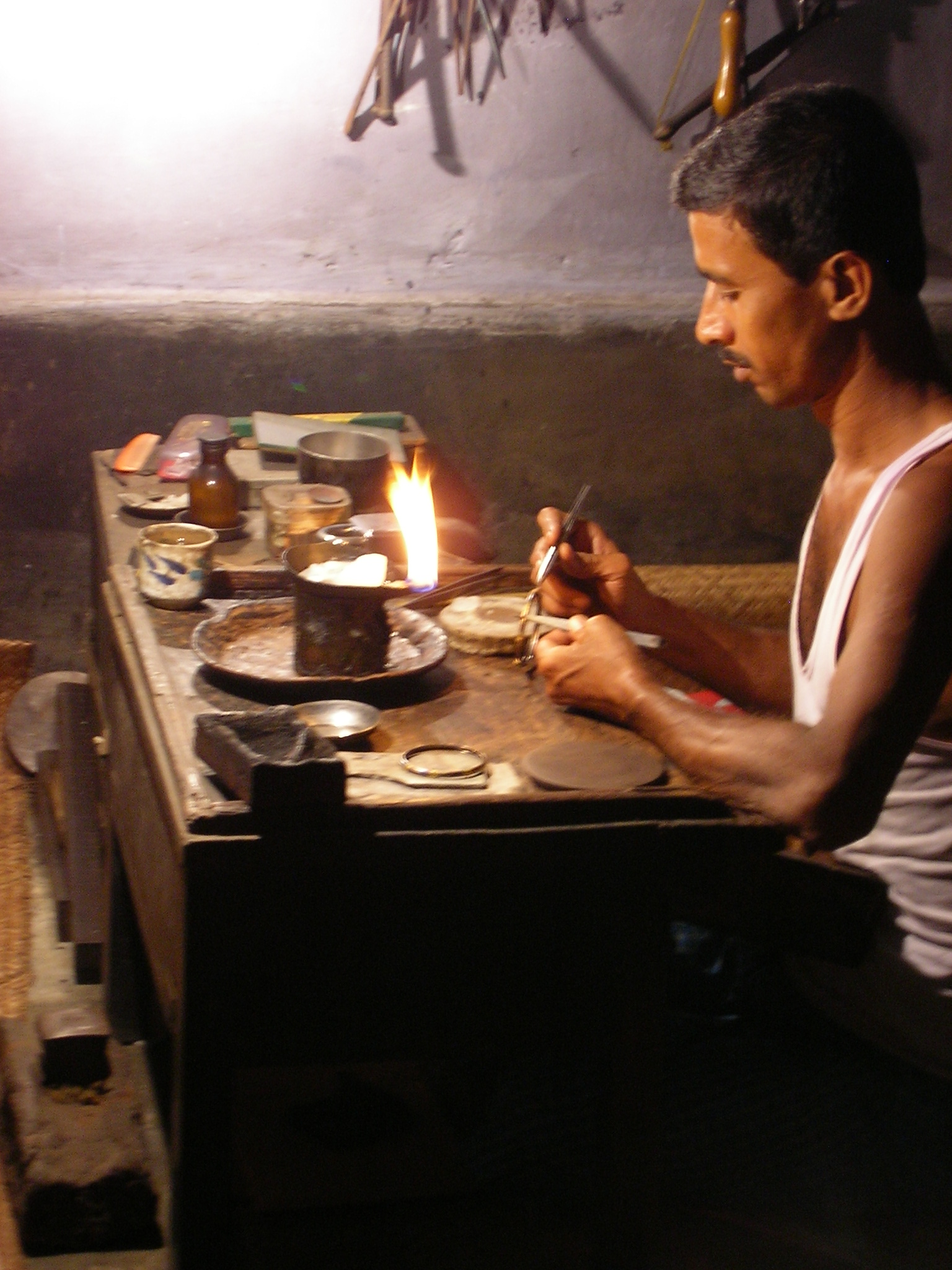 a man in white shirt sitting next to a table