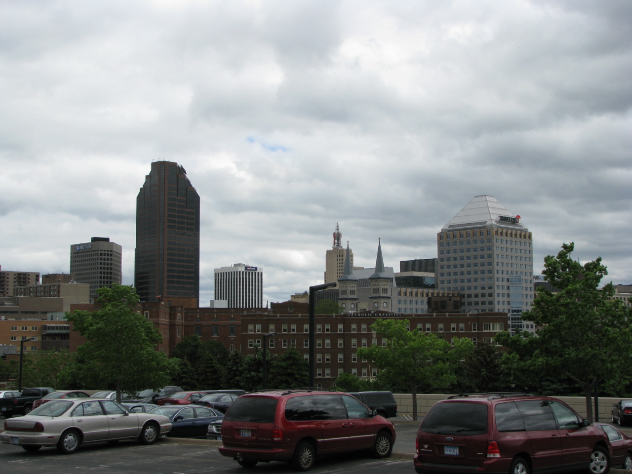 cars are parked in the lot next to a city with buildings