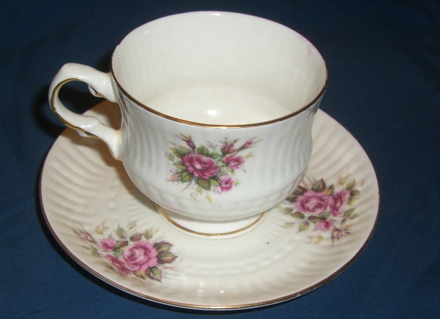 a coffee cup on a saucer with flowers painted all over it
