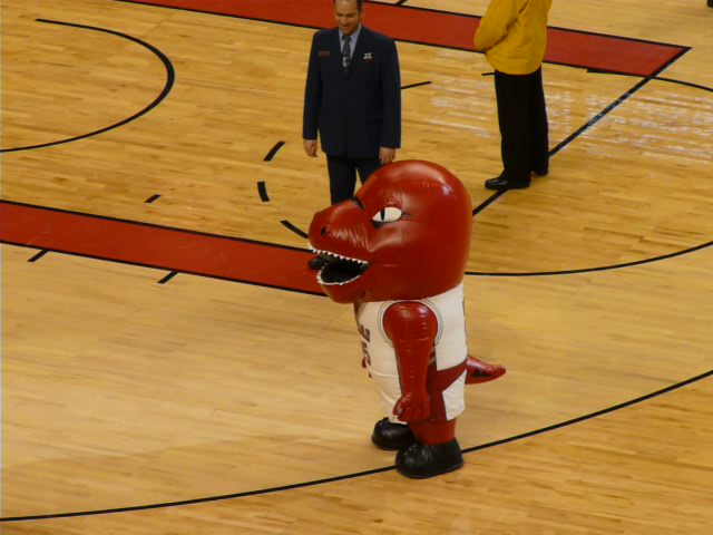 a man in a suit is next to a mascot