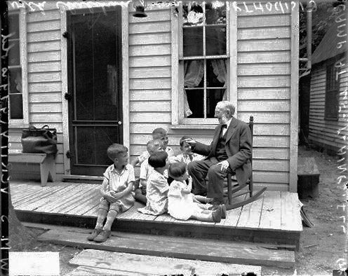 a family sitting on the steps of their house