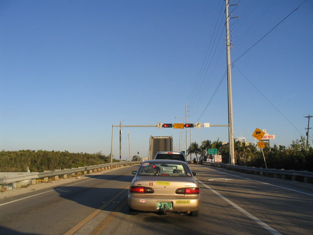 the traffic light is above the vehicle on the highway