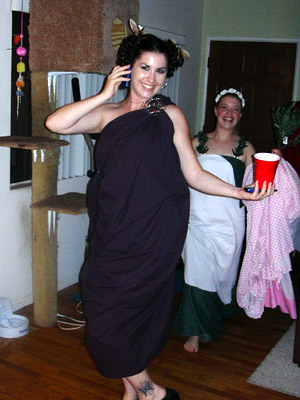 a lady in a funny dress holding a drink on a cell phone