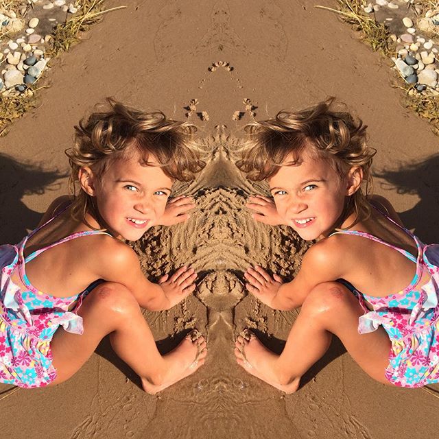 two girls are sitting in the sand next to each other and two of them have their face obscured by the image of themselves