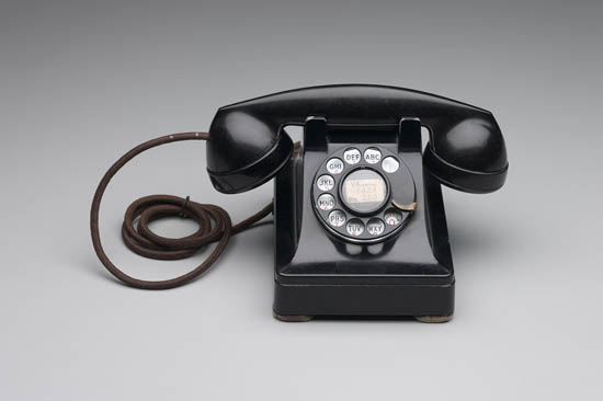 an old black rotary telephone with no handset