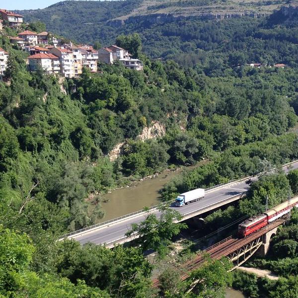 a train traveling over a bridge next to a mountain