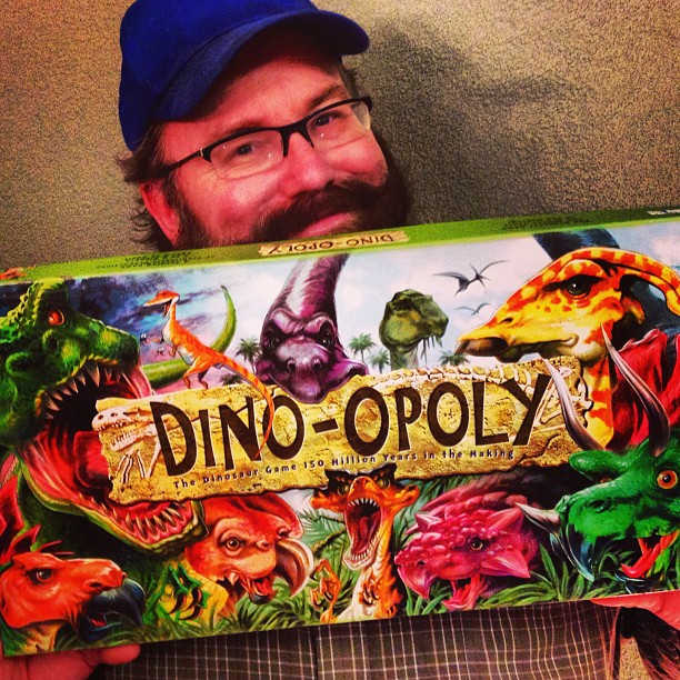 the man is holding up the box for a dinosaur game