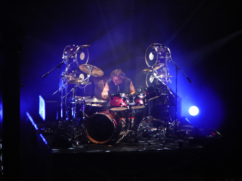 a drummer plays drums in front of several other drums