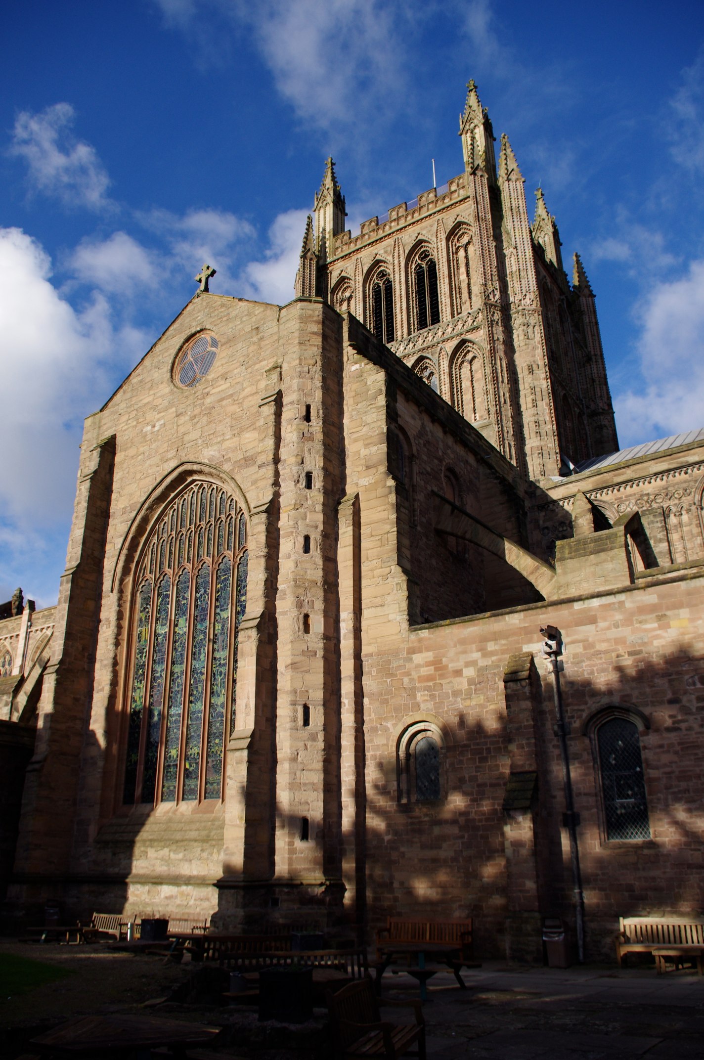 a tall stone cathedral with a steeple, stained glass windows, and clock