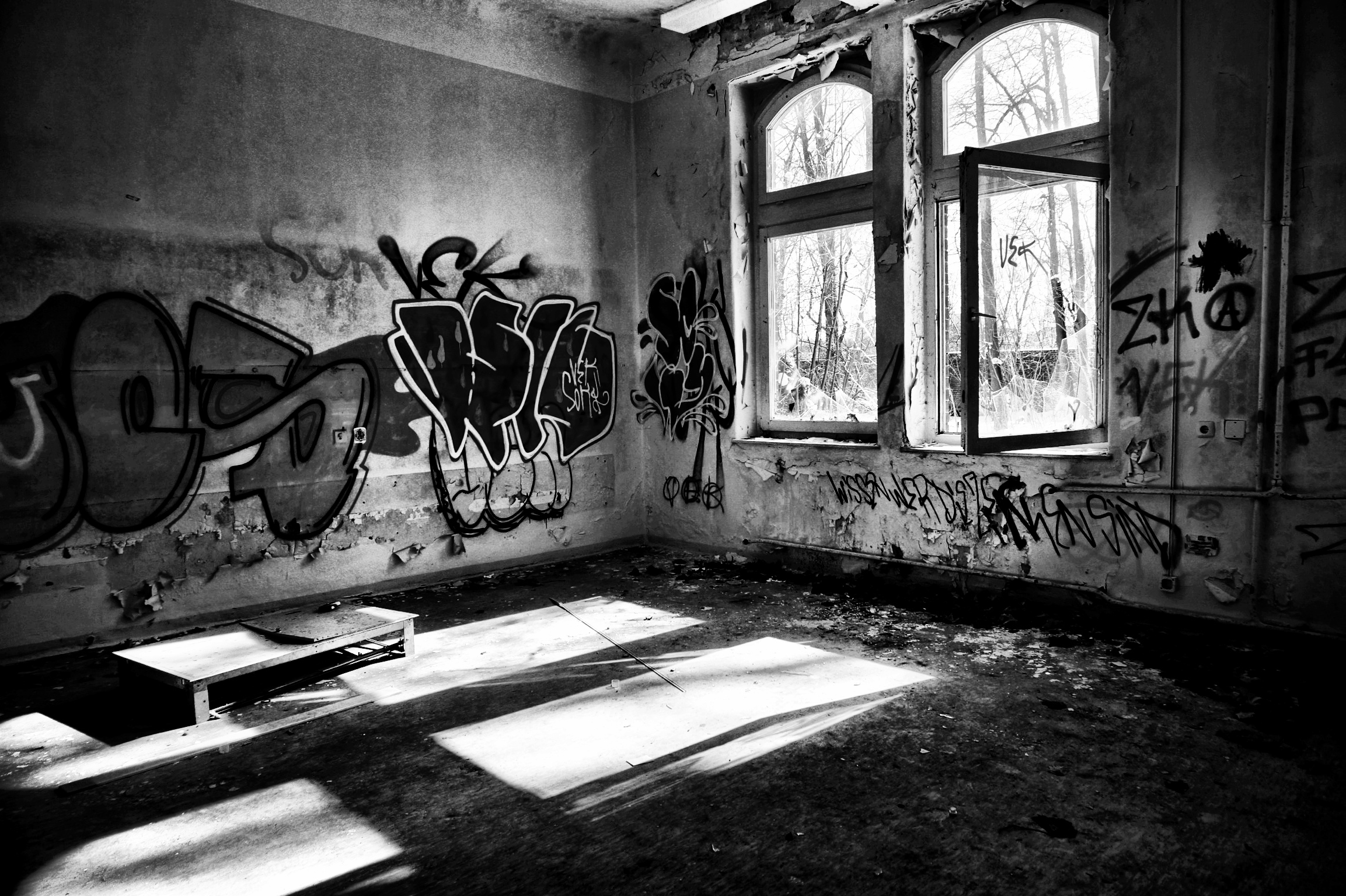 the wall is covered in graffiti and there is no floor in the room