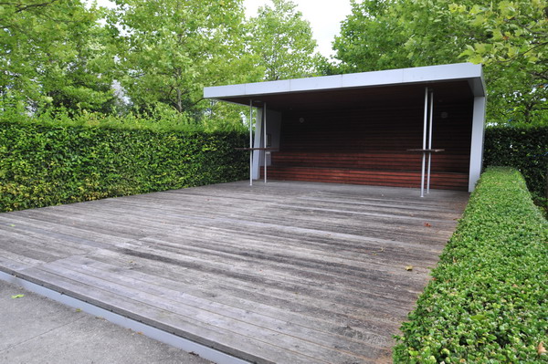 an empty deck area with plants and a wooden structure