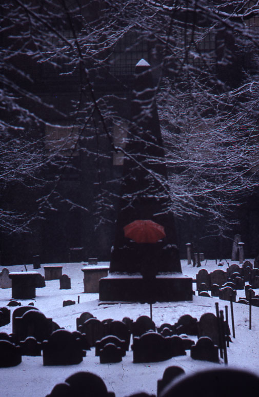 a cemetery filled with tombstones and an umbrella
