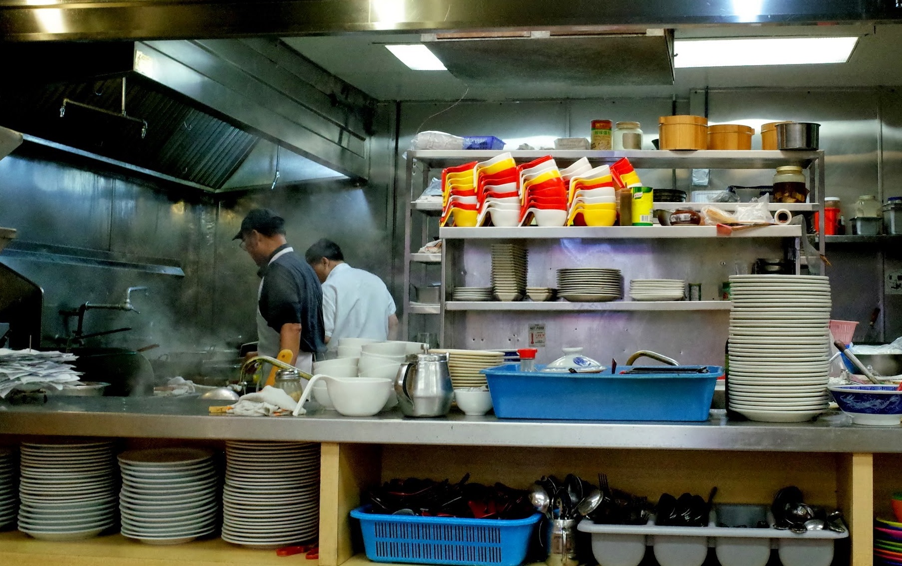 two chefs preparing meals in a commercial kitchen