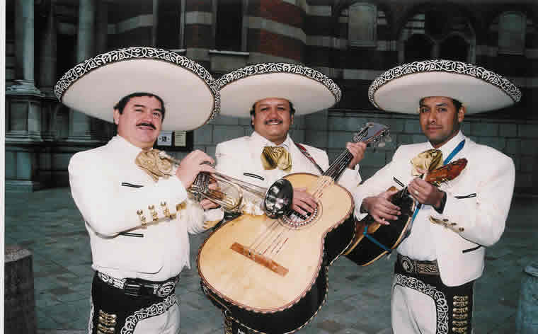 three men in mexican costumes holding a guitar