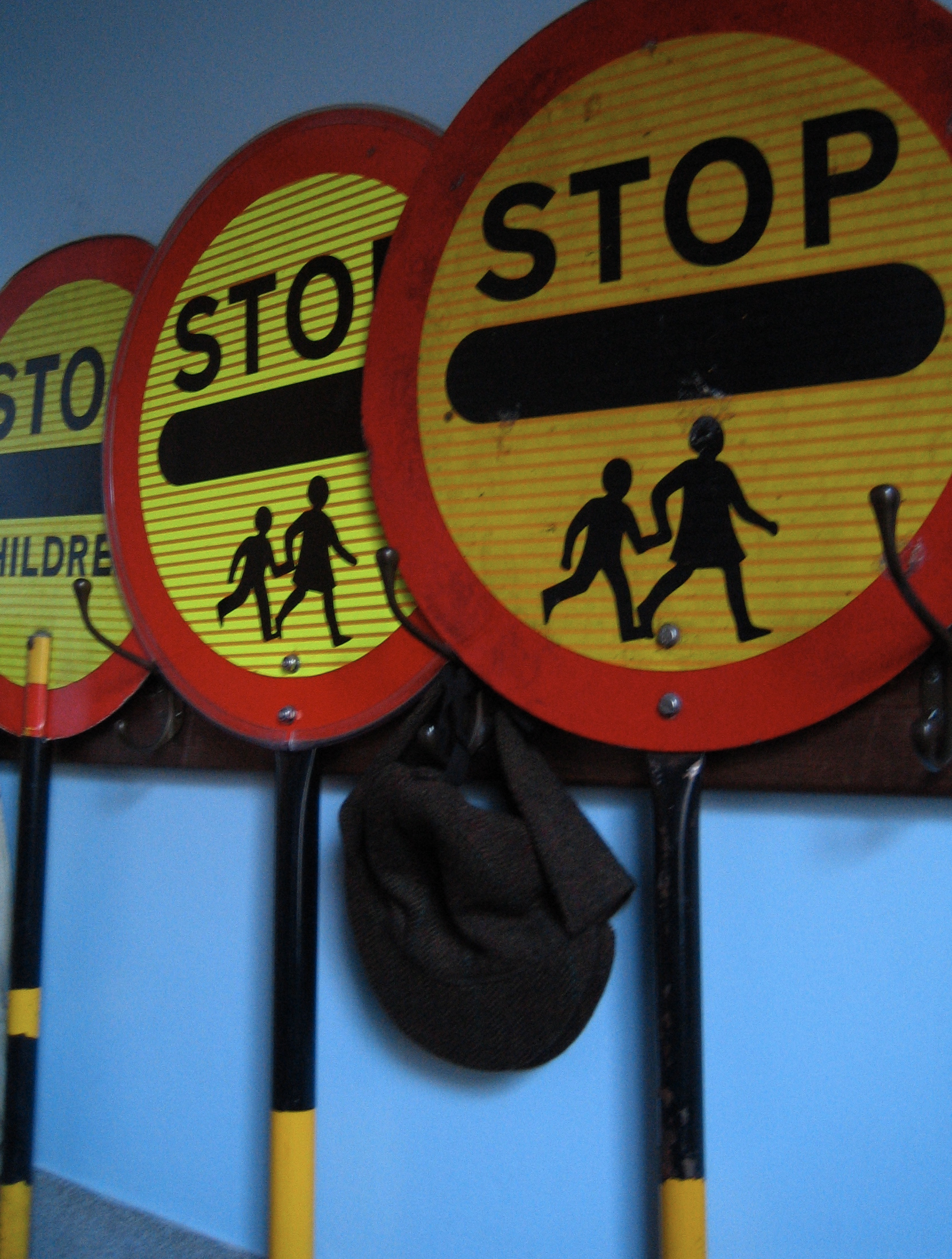 five traffic signs with hats hanging from a wall