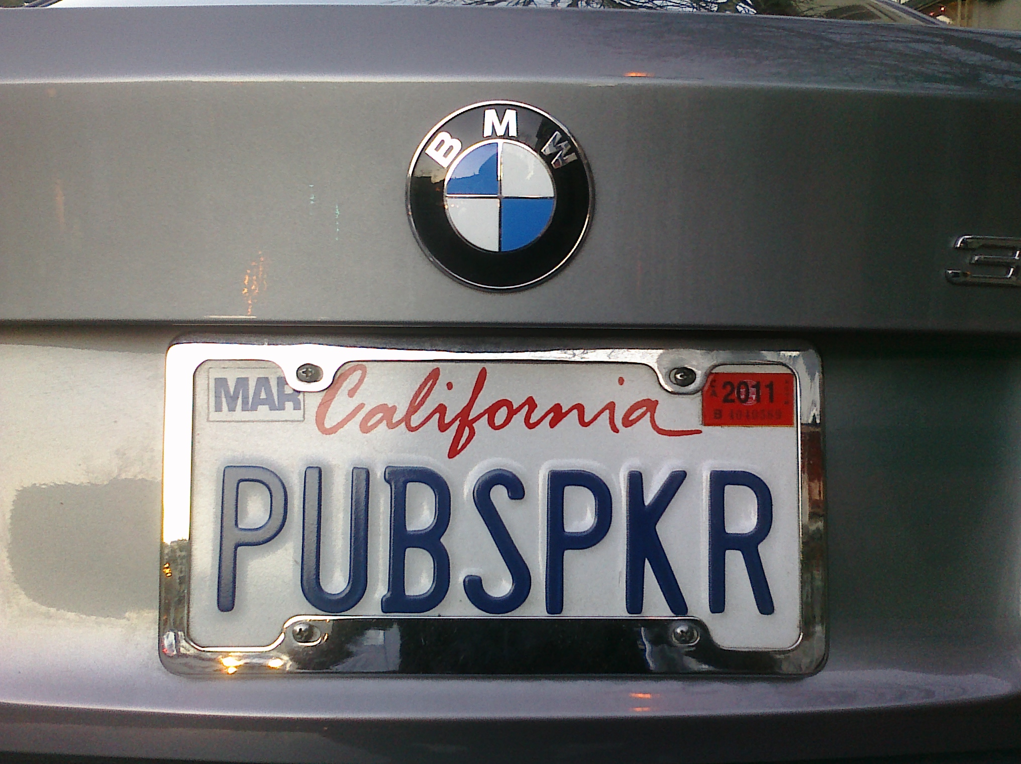a chrome colored bmw license plate with the word pubspkr underneath it