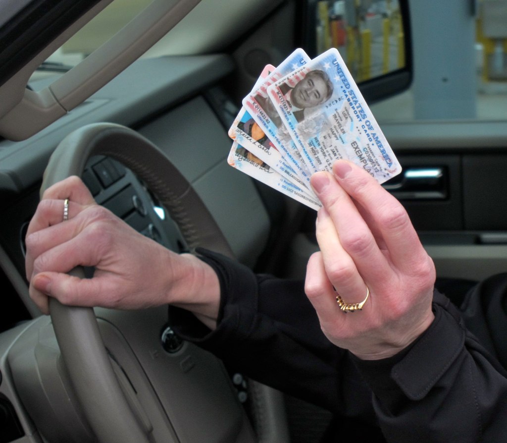 a person holding money in their hand and driving a car