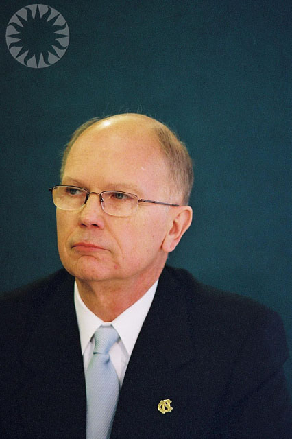 a man in a suit with glasses looking into the distance