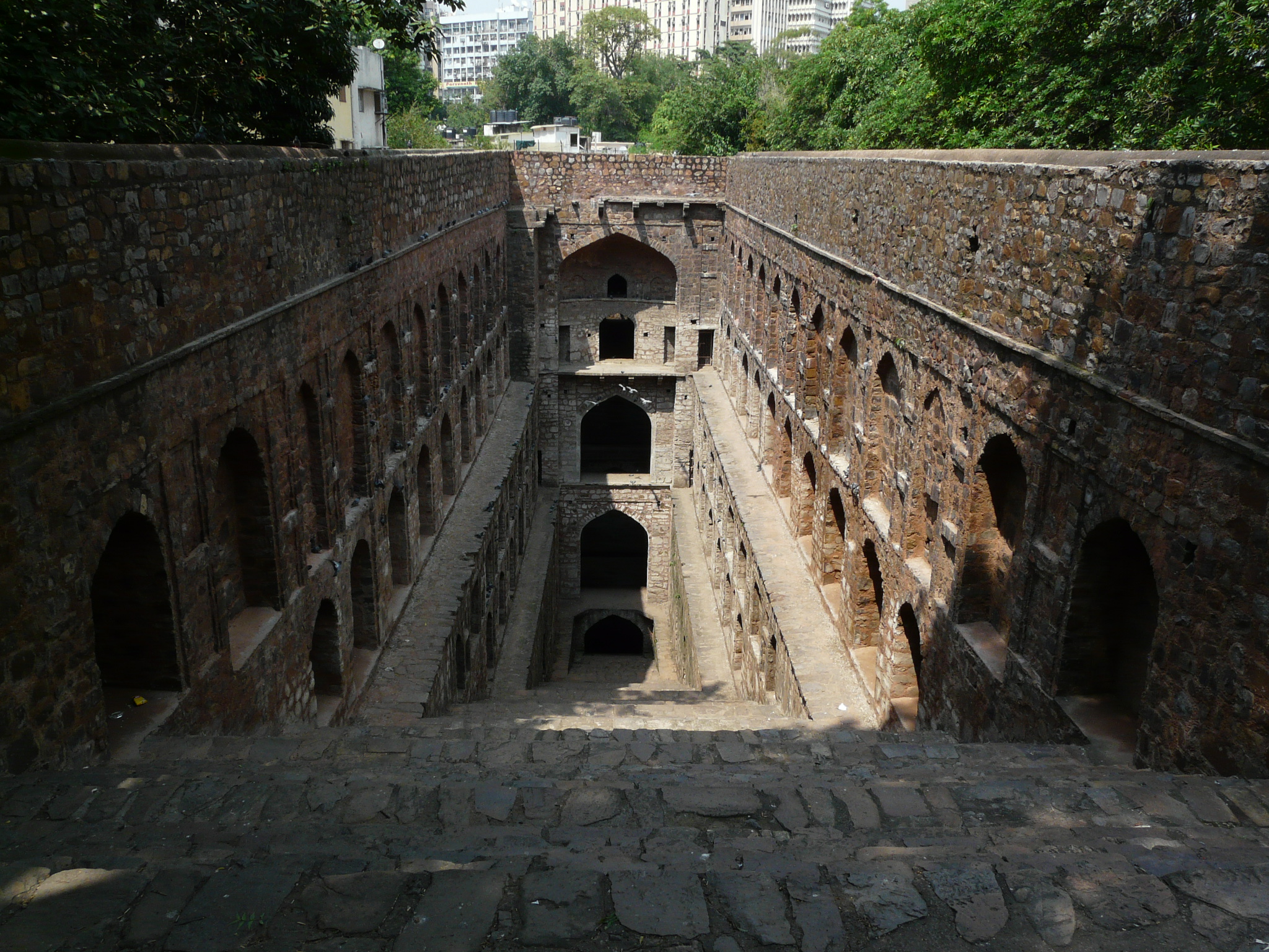 a stone tunnel in the wall is set inside a park