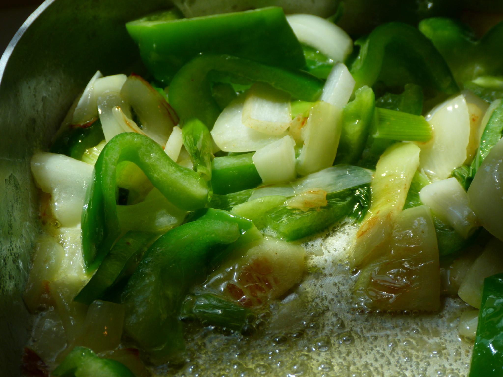 a mixture of vegetables cooking in a wok