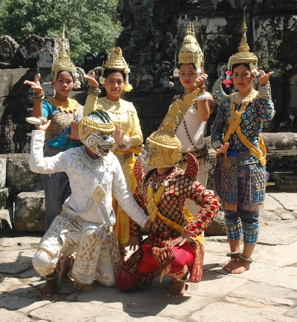 a group of children in costume are pointing towards a statue