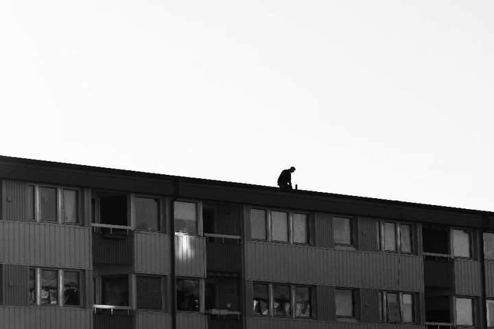 a man on a roof overlooking the sky
