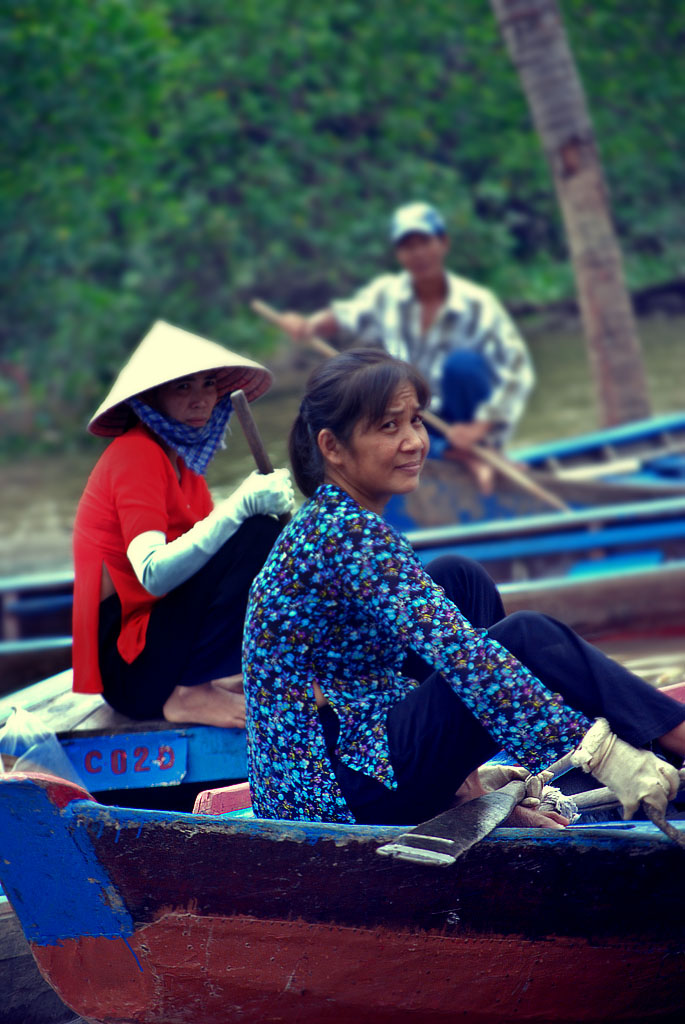 people sitting in a row boat on the water